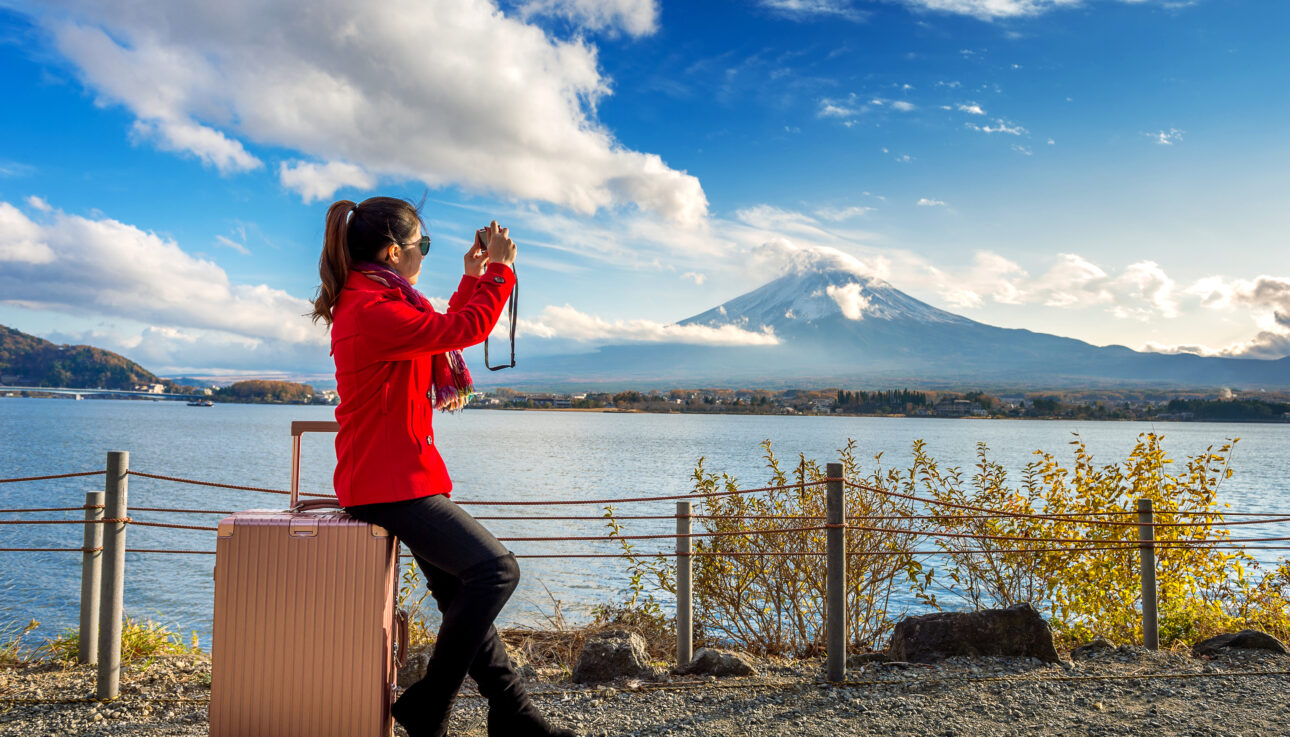 Scenic view of Mount Fuji with cherry blossoms in full bloom, symbolizing the beauty of Japan travel packages.