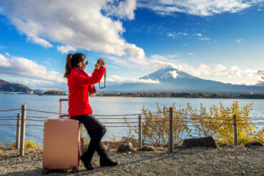 Scenic view of Mount Fuji with cherry blossoms in full bloom, symbolizing the beauty of Japan travel packages.